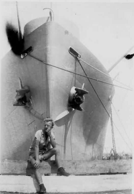 Paul Metro poses in front of a ship on Tinian Island